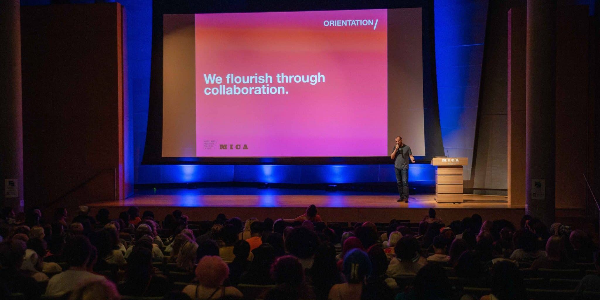 Event Recording and Live Streaming example: A man stands on stage with a large pink slide behind him reading "We flourish through collaboration." An audience pays attention.